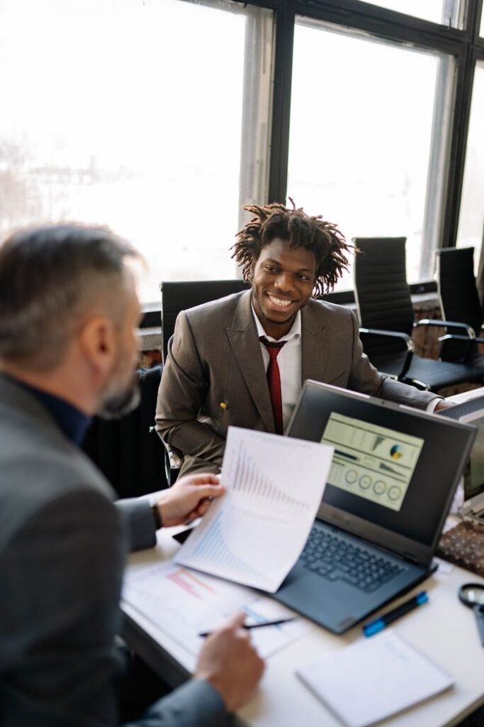 Colleagues discussing financial reports in an office setting, emphasizing teamwork.